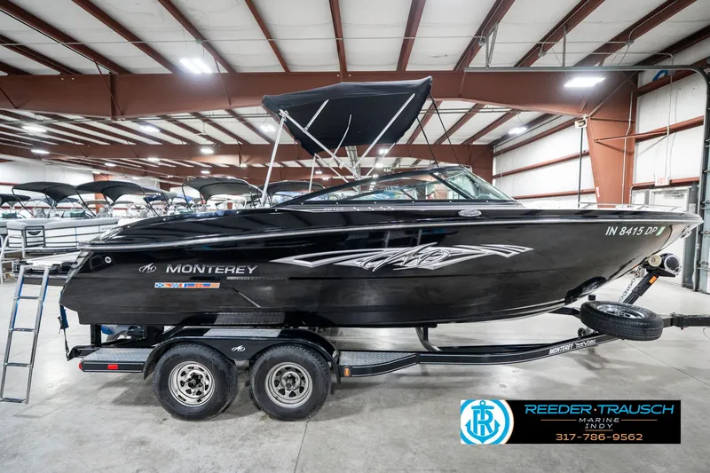 Slide: The Image of 2013 Monterey 232 SS boat in showroom, black exterior, on trailer, with canopy. - 7