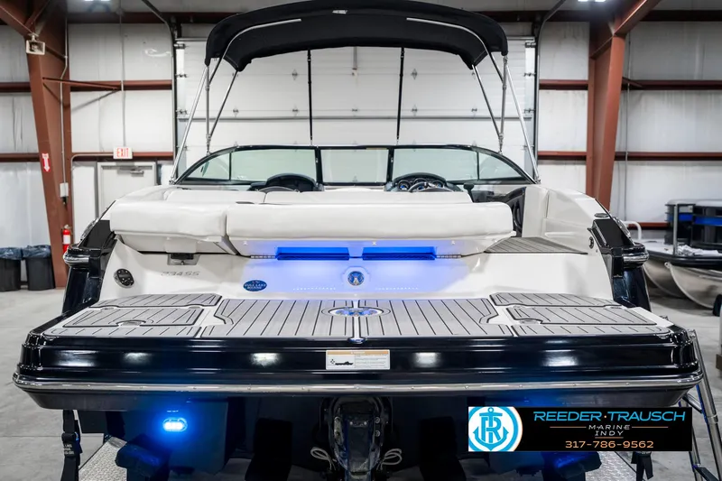 Slide: The Image of 2013 Monterey 232 SS boat in showroom with blue LED lights and black canopy. - 9