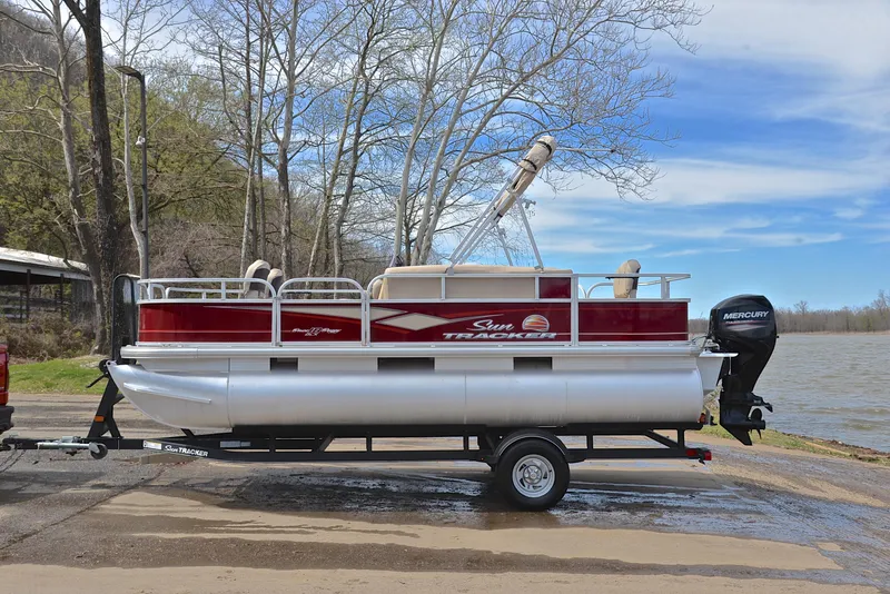Slide: The Image of 2018 Sun Tracker Bass Buggy 18 DLX pontoon boat on trailer by a lake. - 11