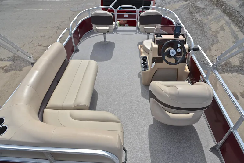 Slide: The Image of 2018 Sun Tracker Bass Buggy 18 DLX pontoon boat interior with beige seating and steering console. - 18