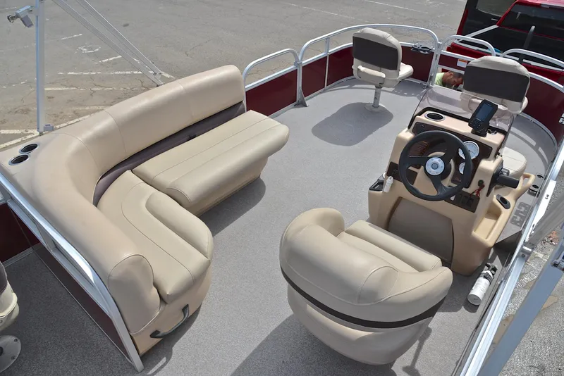 Slide: The Image of 2018 Sun Tracker Bass Buggy 18 DLX pontoon boat interior with beige seating and steering console. - 19