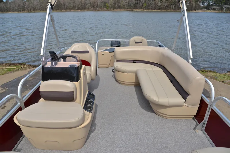 Slide: The Image of 2018 Sun Tracker Bass Buggy 18 DLX pontoon boat with beige seating on a lake. - 20