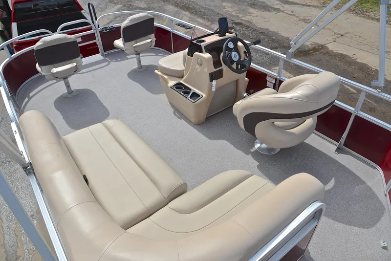 Slide: The Image of 2018 Sun Tracker Bass Buggy 18 DLX pontoon boat interior with beige seating and steering console. - 25
