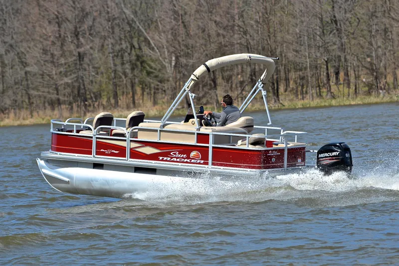 Slide: The Image of 2018 Sun Tracker Bass Buggy 18 DLX pontoon boat cruising on a lake. - 4
