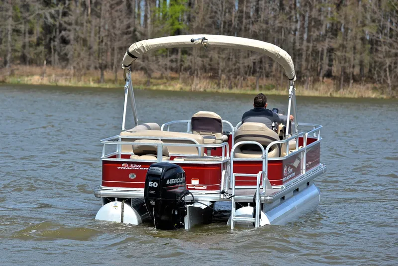 Slide: The Image of 2018 Sun Tracker Bass Buggy 18 DLX pontoon boat cruising on a lake. - 7