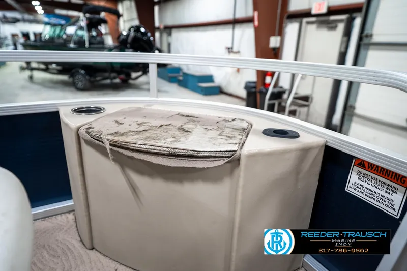 Slide: The Image of 2011 Bennington 20 SFI boat interior with worn seating and cup holders in a showroom. - 22