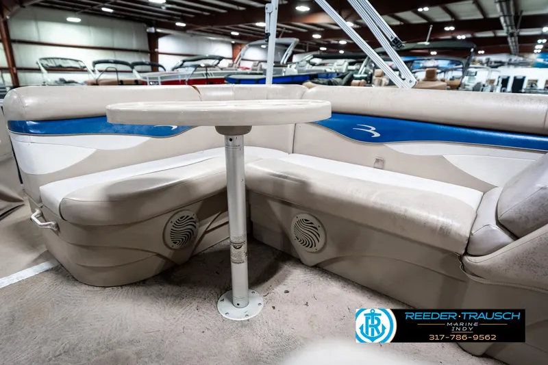Slide: The Image of 2011 Bennington 20 SFI pontoon boat interior with seating and table in showroom. - 26