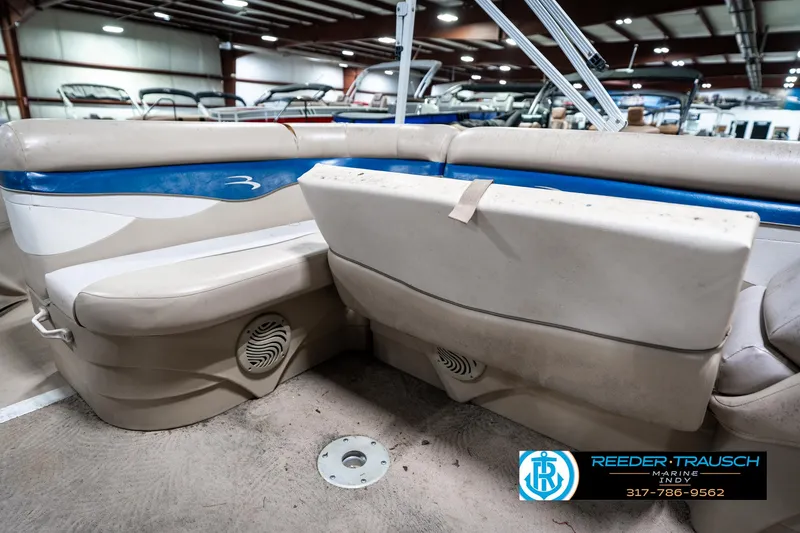 Slide: The Image of 2011 Bennington 20 SFI boat interior with beige and blue seating in a showroom. - 28
