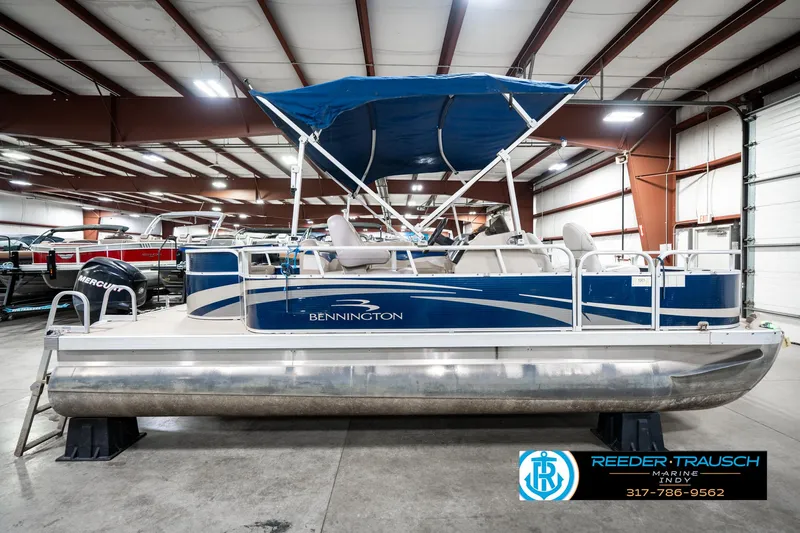 Slide: The Image of 2011 Bennington 20 SFI pontoon boat with blue canopy in indoor showroom. - 7