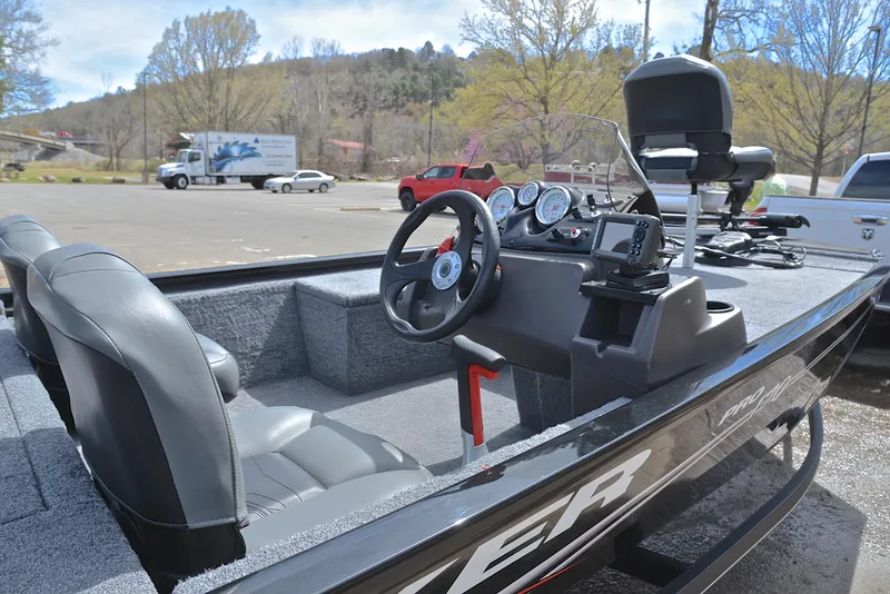Slide: The Image of 2023 Bass Tracker Pro 170 boat interior with steering wheel and dashboard, parked outdoors. - 19
