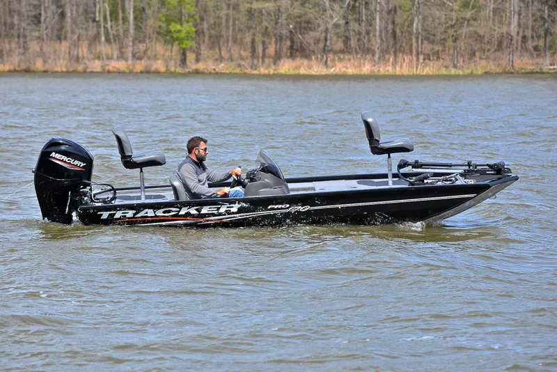Slide: The Image of 2023 Bass Tracker Pro 170 boat on a lake with a person driving. - 7