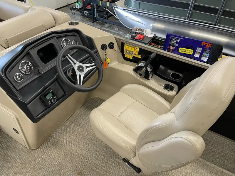 Slide: The Image of 2021 Bentley Pontoons Legacy 200 Cruise RE helm with beige seating and control panel. - 11