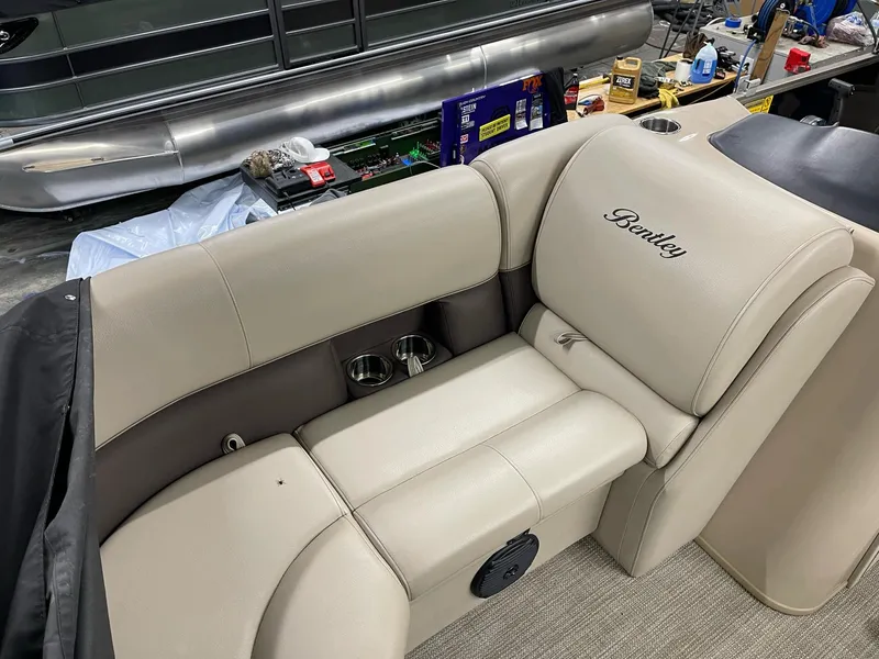 Slide: The Image of 2021 Bentley Pontoons Legacy 200 Cruise RE interior seating with cup holders and beige upholstery. - 7