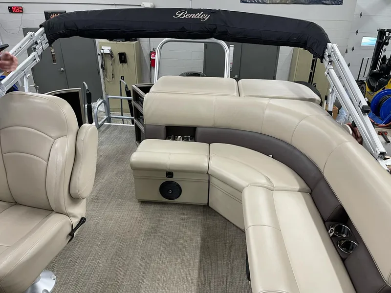 Slide: The Image of 2021 Bentley Pontoons Legacy 200 Cruise RE interior with beige seating and black canopy. - 8
