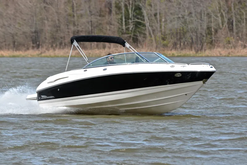 Slide: The Image of 2004 Chaparral 220 SSi boat cruising on a lake with forested background. - 1