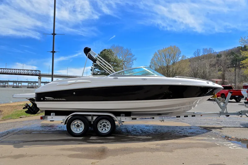 Slide: The Image of 2004 Chaparral 220 SSi boat on trailer by riverside, under clear blue sky. - 15
