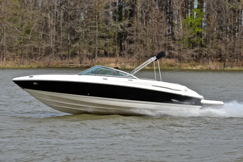 Slide: The Image of 2004 Chaparral 220 SSi boat cruising on a lake with forested background. - 2