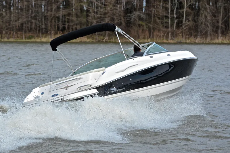 Slide: The Image of 2004 Chaparral 220 SSi boat cruising on a lake with trees in the background. - 5