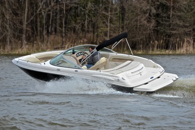 Slide: The Image of 2004 Chaparral 220 SSi boat cruising on a lake with forest background. - 6