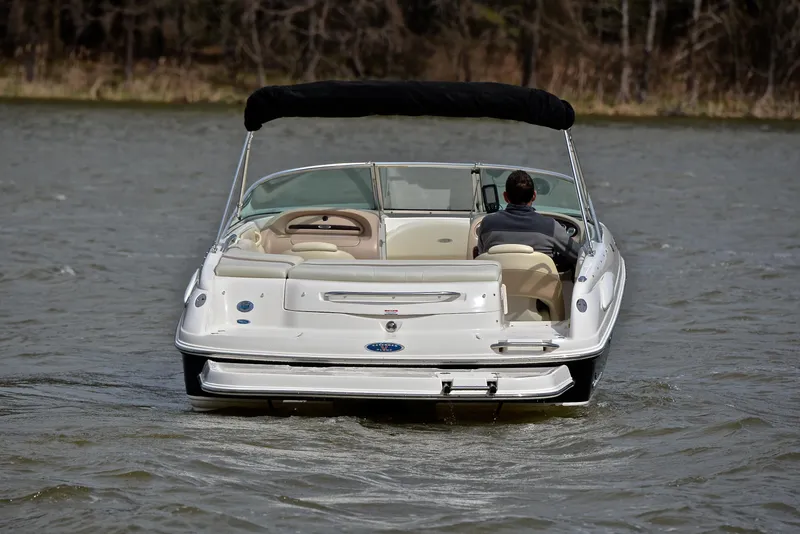 Slide: The Image of 2004 Chaparral 220 SSi boat cruising on a lake with a person at the helm. - 8