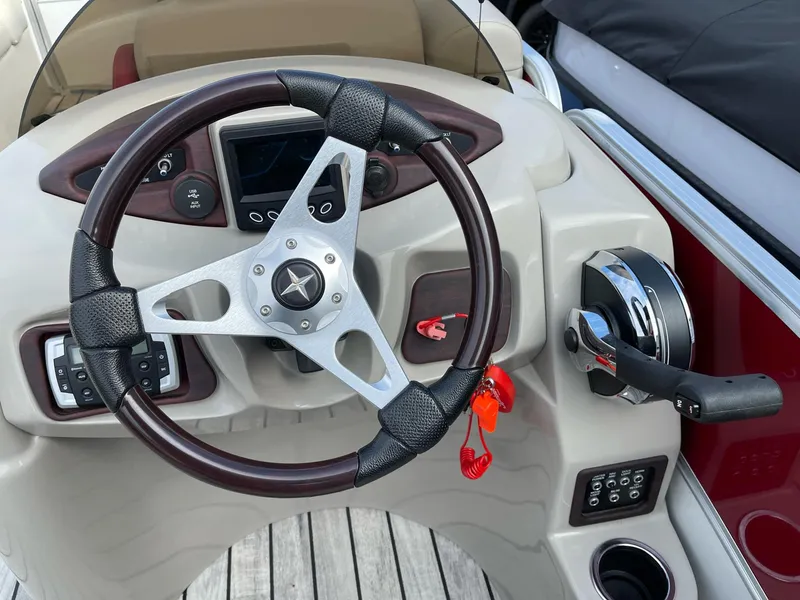 Slide: The Image of Steering wheel and controls of a 2016 Berkshire 233RFX STS boat. - 14