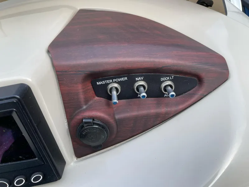Slide: The Image of Control panel of 2016 Berkshire 233RFX STS boat with switches for power, navigation, and dock lights. - 17