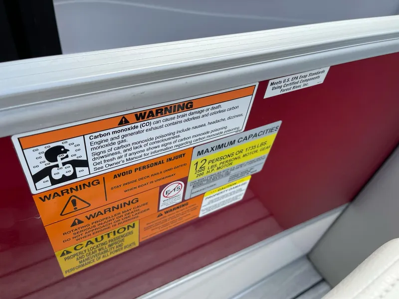 Slide: The Image of Warning labels on 2016 Berkshire 233RFX STS boat, highlighting safety and capacity information. - 19