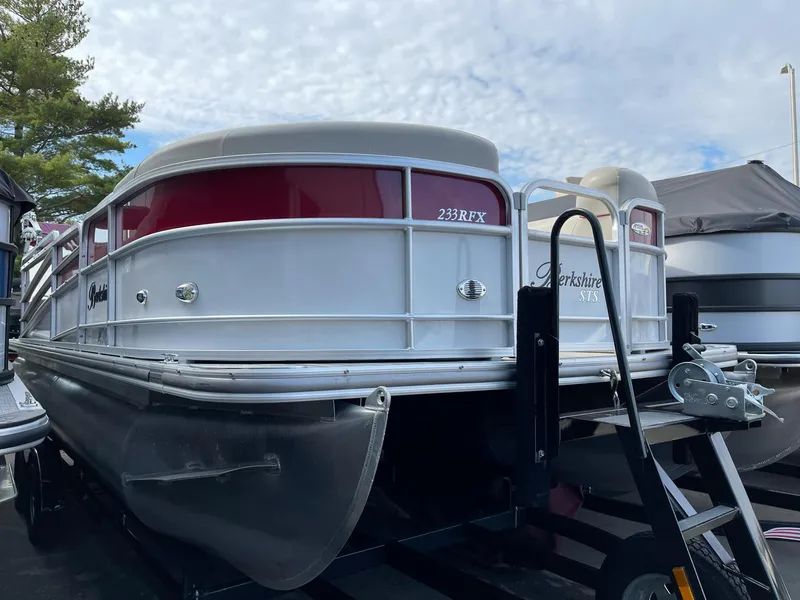 Slide: The Image of 2016 Berkshire 233RFX STS pontoon boat on trailer, featuring red and white exterior. - 2