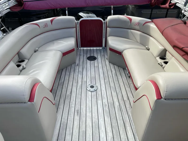Slide: The Image of 2016 Berkshire 233RFX STS boat interior with beige and red seating, wooden flooring. - 20