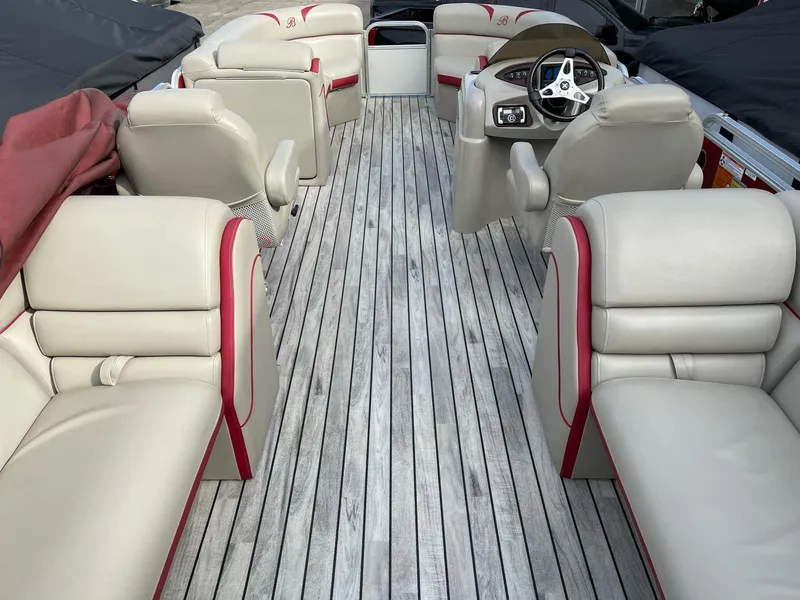 Slide: The Image of 2016 Berkshire 233RFX STS boat interior with beige and red seating, wood-style flooring. - 21