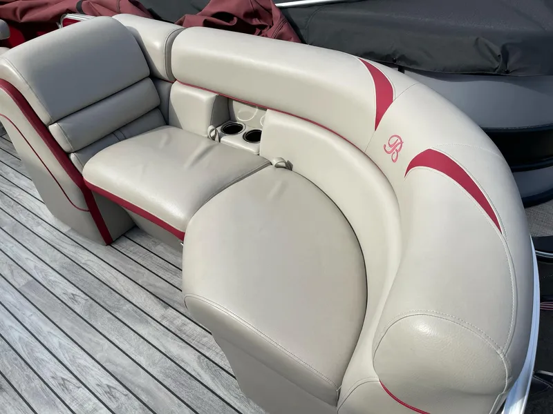 Slide: The Image of 2016 Berkshire 233RFX STS boat seating with beige and red upholstery on wooden deck. - 7