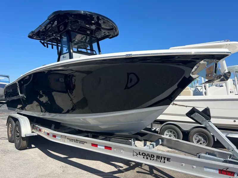 Slide: The Image of 2025 Sea Pro 245 FLX boat on trailer, black hull, sunny day. - 1