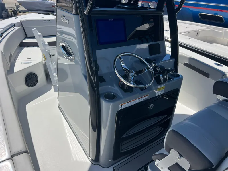 Slide: The Image of 2025 Sea Pro 245 FLX boat interior with modern steering console and seating. - 11