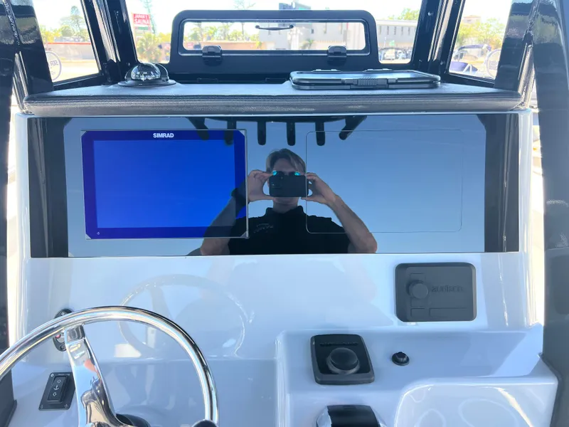 Slide: The Image of 2025 Sea Pro 245 FLX boat dashboard with steering wheel and navigation screen. - 13