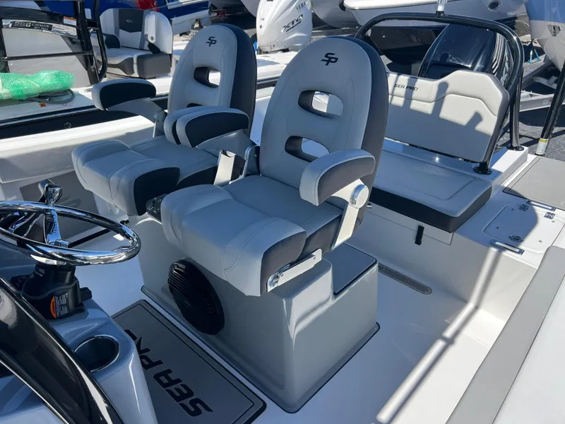 Slide: The Image of 2025 Sea Pro 245 FLX boat interior with dual captain's chairs and steering wheel. - 16