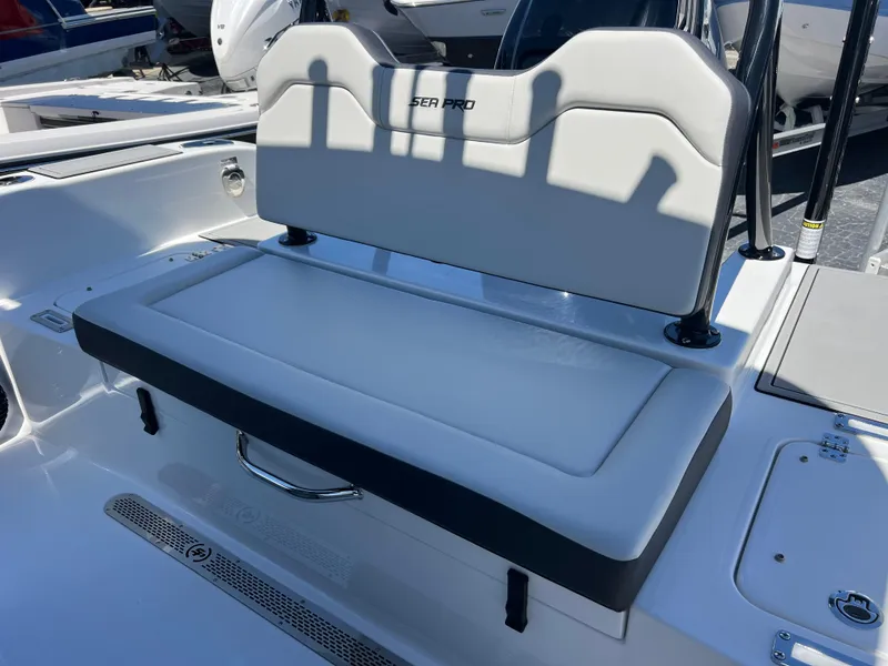 Slide: The Image of 2025 Sea Pro 245 FLX boat seat with white cushioned backrest and storage compartment. - 18