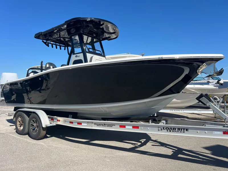 Slide: The Image of 2025 Sea Pro 245 FLX boat on a Load Rite trailer, parked outdoors. - 2