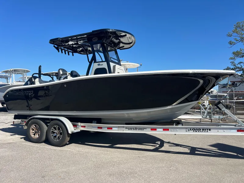 Slide: The Image of 2025 Sea Pro 245 FLX boat on trailer, black hull, sunny day. - 3