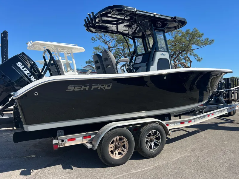 Slide: The Image of 2025 Sea Pro 245 FLX boat on trailer, black hull, outdoor setting. - 5