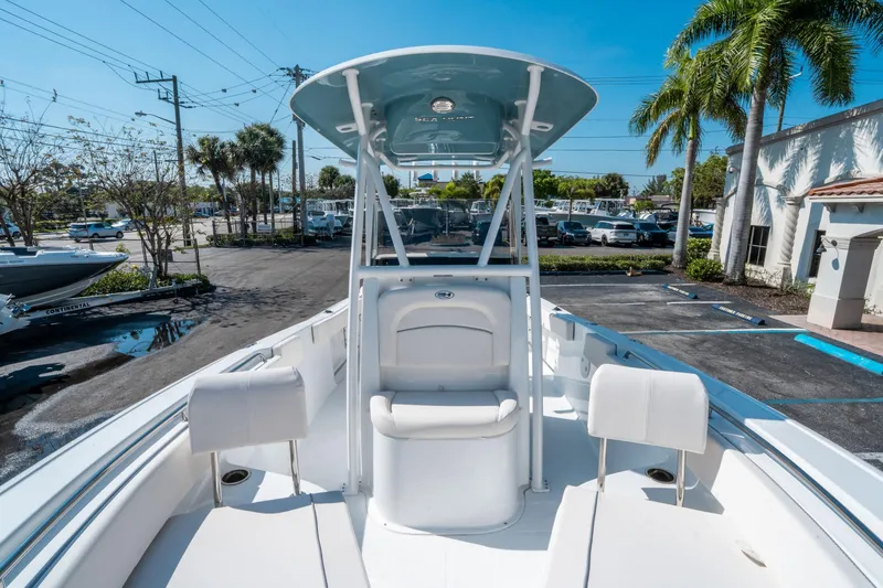 Slide: The Image of 2025 Sea Hunt Ultra 229 boat with T-top, parked in a sunny marina. - 22
