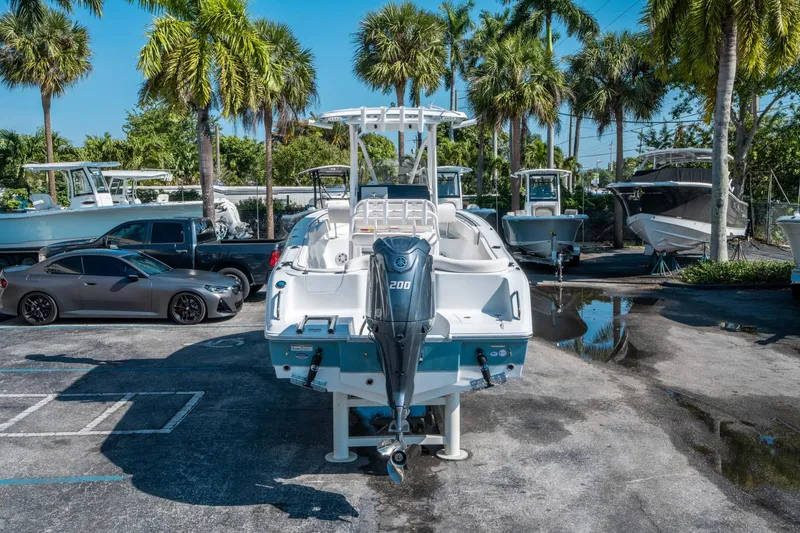 Slide: The Image of 2025 Sea Hunt Ultra 229 boat with Yamaha 200 engine, parked near palm trees. - 3
