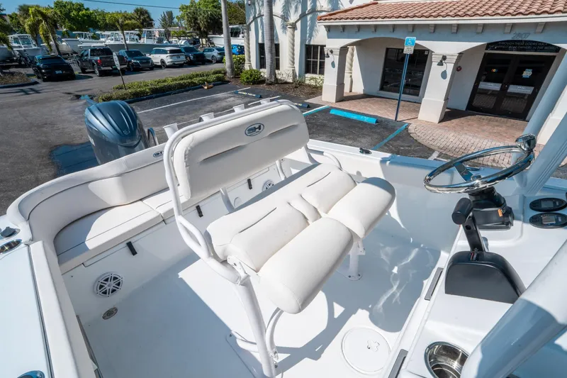 Slide: The Image of 2025 Sea Hunt Ultra 229 boat interior with white seating and steering wheel. - 18
