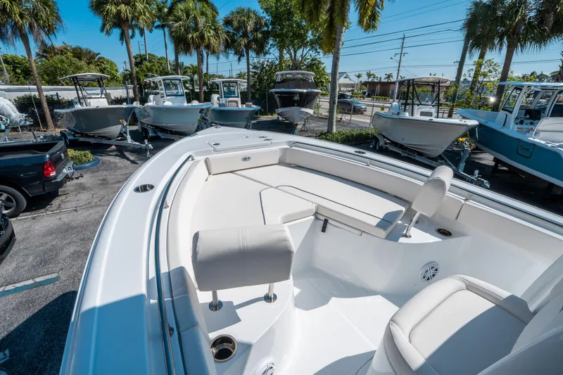 Slide: The Image of 2025 Sea Hunt Ultra 229 boat with spacious seating, displayed outdoors under palm trees. - 20