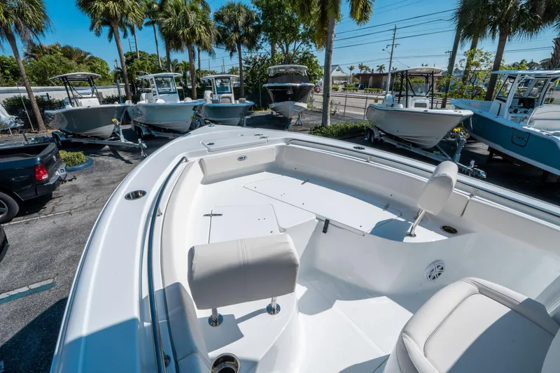 Slide: The Image of 2025 Sea Hunt Ultra 229 boat displayed outdoors with palm trees in the background. - 23