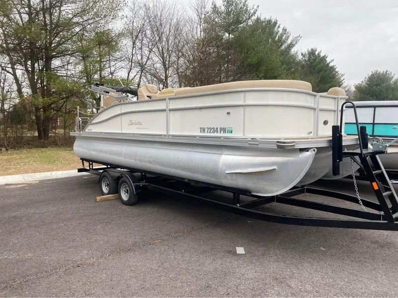 Slide: The Image of 2021 Barletta C22CC pontoon boat on trailer in parking lot. - 1
