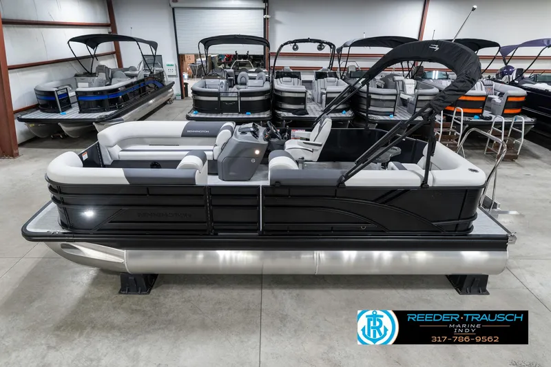 Slide: The Image of 2025 Bennington 21 SL pontoon boat displayed in a showroom with other boats. - 1