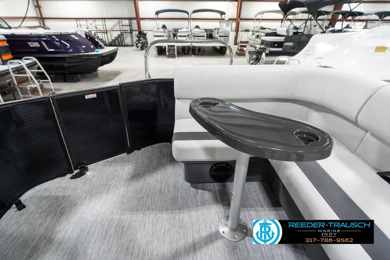 Slide: The Image of 2025 Bennington 21 SL pontoon boat interior with seating and table in showroom. - 18