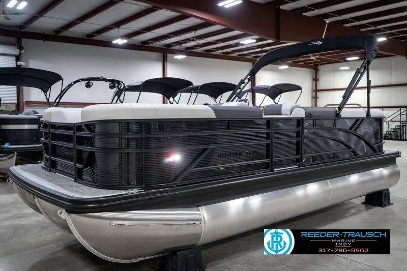 Slide: The Image of 2025 Bennington 21 SL pontoon boat in showroom, featuring sleek design and modern amenities. - 2