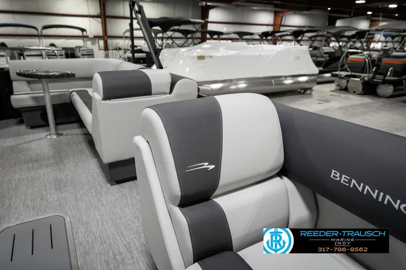 Slide: The Image of 2025 Bennington 21 SL pontoon boat interior with gray and white seating in showroom. - 23