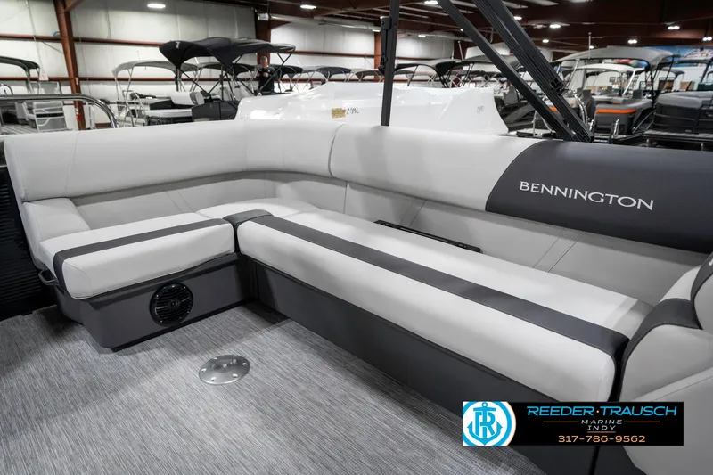 Slide: The Image of 2025 Bennington 21 SL pontoon boat interior with gray seating in a showroom. - 26